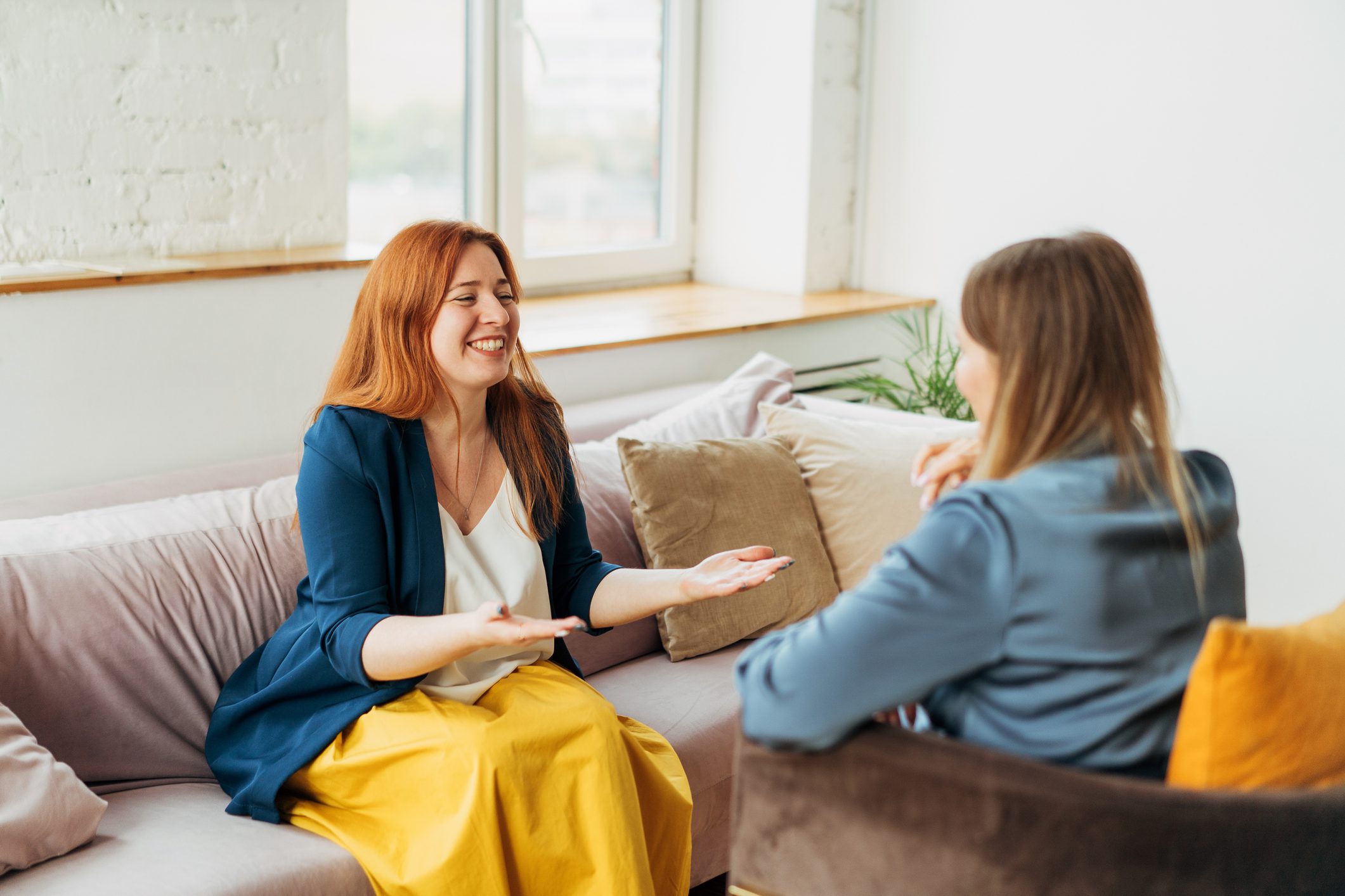 Two women, a psychiatrist and her patient, in armchairs are sitting and talking