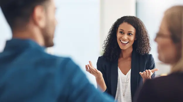 passionate-staff-img A woman engages in conversation with two men in a professional office setting, showcasing collaboration and communication