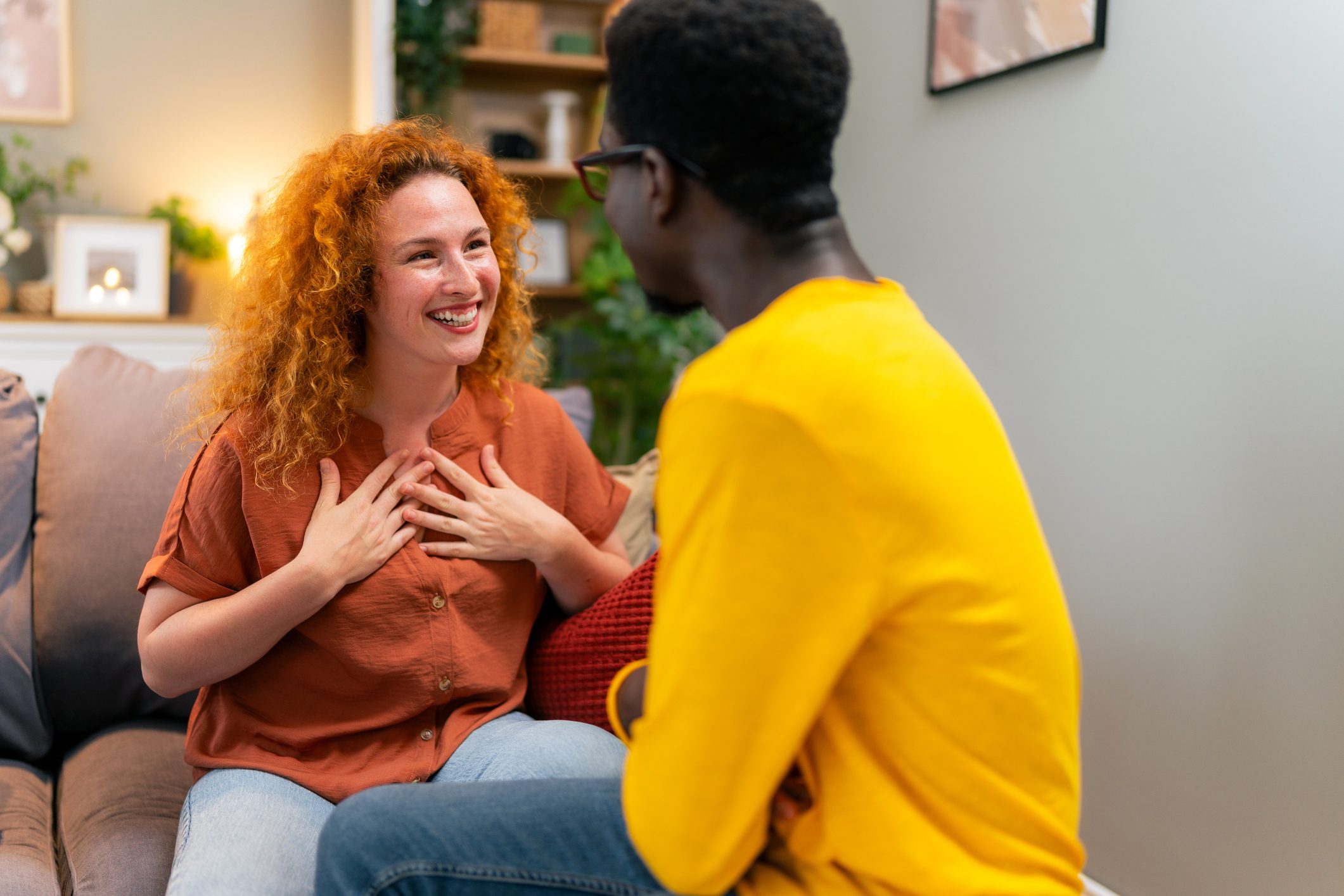 Woman with curly red hair smiles during a therapy session